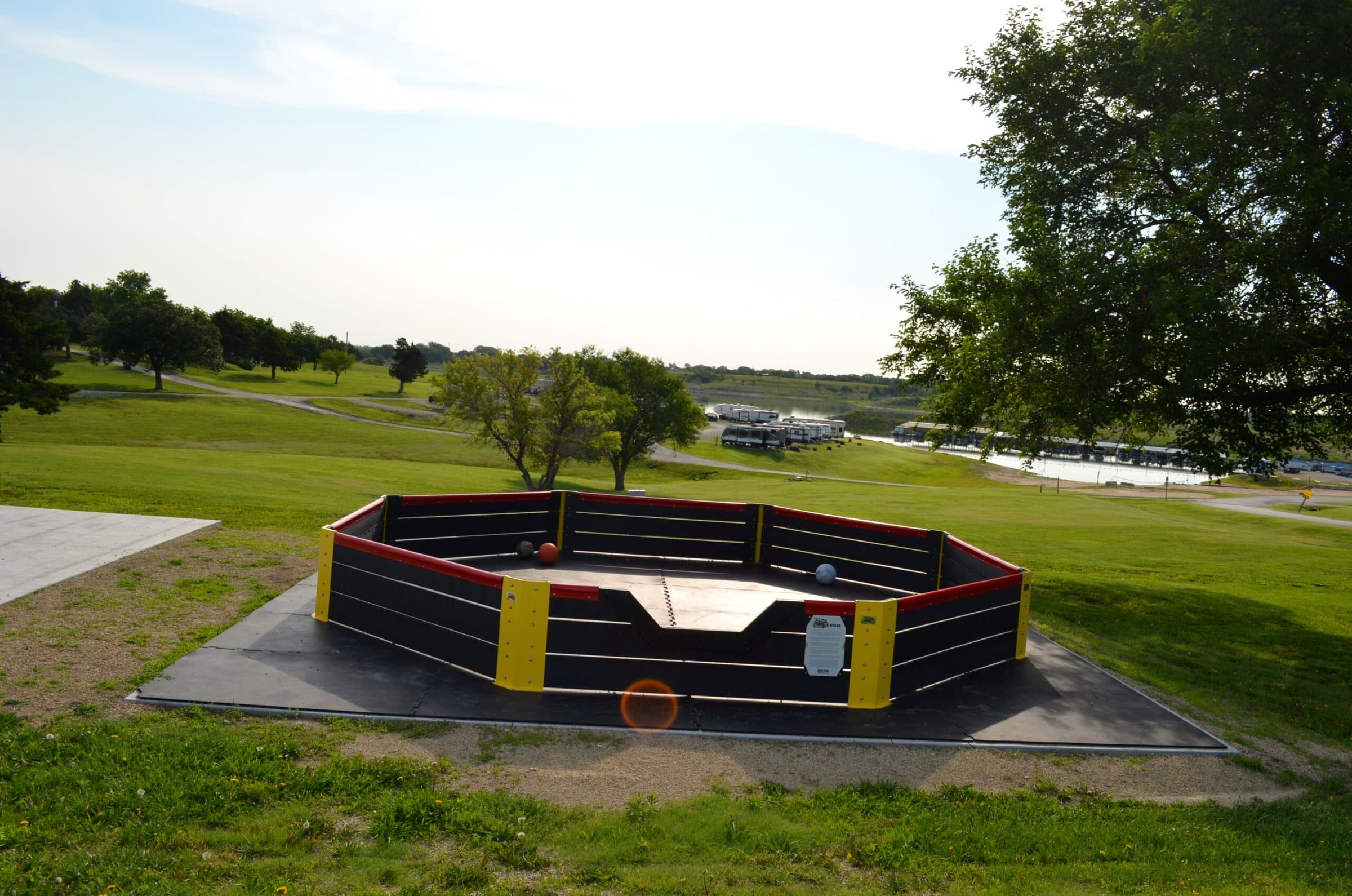 Octagonal gaga ball pit with black and yellow walls on a concrete pad
